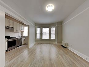 San Francisco apartment for rent - an empty living room and kitchen with wood floors and windows