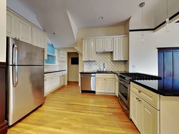 San Francisco apartment for rent - A kitchen with wooden floors and white cabinets.