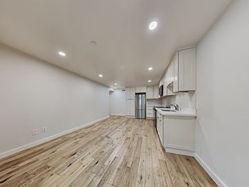 San Francisco apartment for rent - an open living room and kitchen with wood floors and white walls