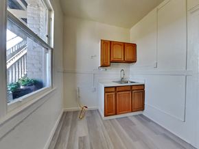 San Francisco apartment for rent - an empty kitchen with wooden cabinets and a window