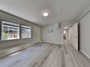 San Francisco apartment for rent - a renovated living room and hallway with wood floors and a large window