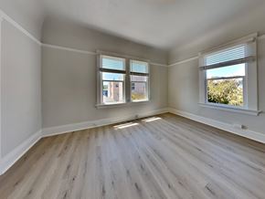 San Francisco apartment for rent - an empty bedroom with wood floors and two windows