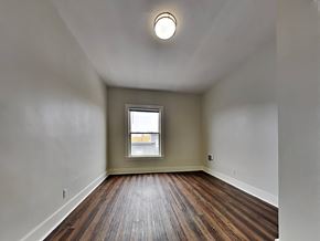 San Francisco apartment for rent - an empty living room with wood floors and a window