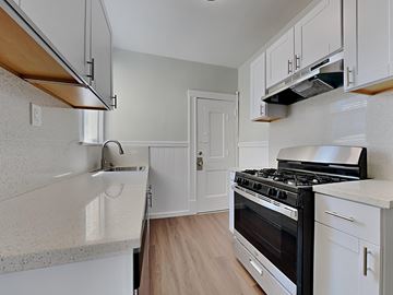 San Francisco apartment for rent - a kitchen with white cabinets and a stove and a sink