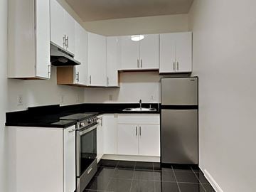 San Francisco apartment for rent - a kitchen with white cabinets and a stainless steel refrigerator