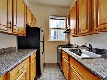 San Francisco apartment for rent - a kitchen with wood cabinets and granite counter tops and a sink
