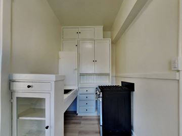 San Francisco apartment for rent - a kitchen with white cabinets and a black stove