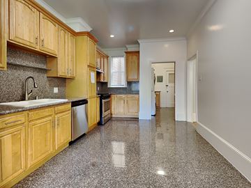 San Francisco apartment for rent - a large kitchen with wooden cabinets and granite floors