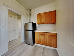San Francisco apartment for rent - a small kitchen with a refrigerator and wooden cabinets