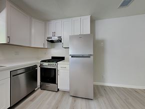 Oakland apartment for rent - an empty kitchen with stainless steel appliances and white cabinets