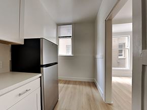 San Francisco apartment for rent - an empty kitchen with a refrigerator and a window