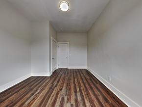 San Francisco apartment for rent - a bedroom with white walls and wood flooring and a door