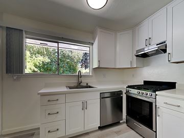 Oakland apartment for rent - a kitchen with white cabinets and stainless steel appliances and a window