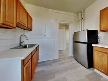San Francisco apartment for rent - a kitchen with a sink and refrigerator and wooden cabinets
