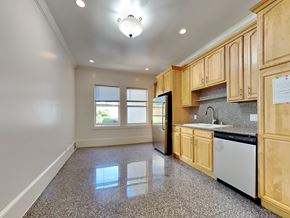 San Francisco apartment for rent - an empty kitchen with wooden cabinets and black appliances