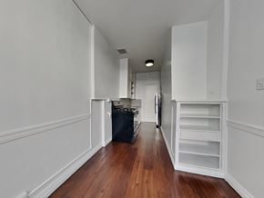 Los Angeles apartment for rent - a living room with white walls and wood floors and a kitchen with white cabinets