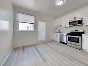 San Francisco apartment for rent - an empty kitchen with white cabinets and stainless steel appliances