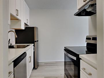 San Francisco apartment for rent - a kitchen with white cabinets and a black stove and a refrigerator