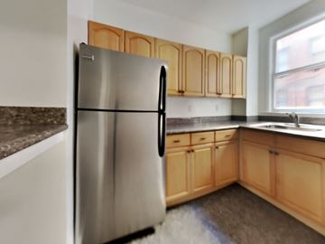 San Francisco apartment for rent - a kitchen with a stainless steel refrigerator and wooden cabinets
