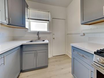 San Francisco apartment for rent - a kitchen with blue cabinets and a sink and a window