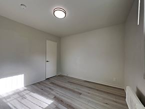 San Francisco apartment for rent - a bedroom with white walls and wood flooring and a door