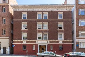 San Francisco apartment for rent - a large brick building with cars parked in front of it
