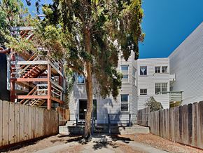 San Francisco apartment for rent - the exterior of an apartment building with a tree and a wooden fence