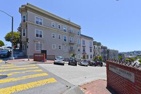 San Francisco apartment for rent - a city street with cars parked in front of a building