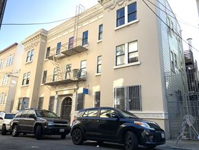 San Francisco apartment for rent - a city street with cars parked in front of a building