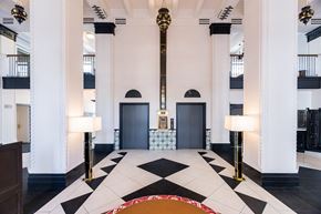 Los Angeles apartment for rent - a view of the lobby of a building with columns and a black and white floor