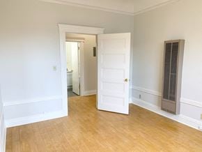 San Francisco apartment for rent - an empty living room with a white door and a wood floor