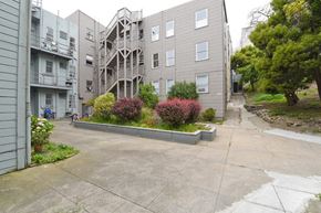 San Francisco apartment for rent - the view of an apartment building with a driveway and landscaping in front of it