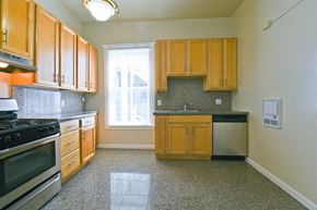 San Francisco apartment for rent - an empty kitchen with wooden cabinets and a window