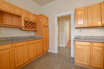San Francisco apartment for rent - a kitchen with wood cabinets and granite counter tops and a door to a hallway