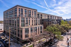 Dallas apartment for rent - A large building with a parking lot in front of it.