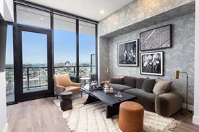 San Diego apartment for rent - A modern living room with a view of the city through large windows.