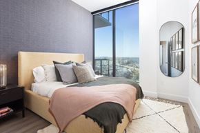 San Diego apartment for rent - A bedroom with a large bed and a view of the city.