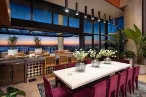 San Diego apartment for rent - A dining room with a table set for six with a view of the city at sunset.
