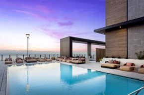 San Diego apartment for rent - A modern poolside lounge area with a view of the water.