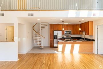 Edgewater apartment for rent - A modern kitchen with wooden cabinets and a spiral staircase.
