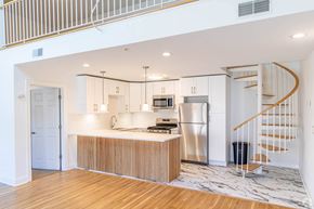 Edgewater apartment for rent - A modern kitchen with a wooden floor and stainless steel appliances.