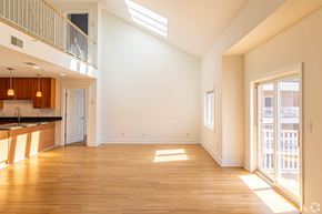 Edgewater apartment for rent - A spacious, empty room with wooden floors and a skylight.