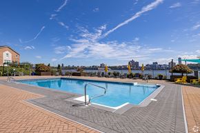 Edgewater apartment for rent - A large outdoor swimming pool with a tiled edge and a diving board.