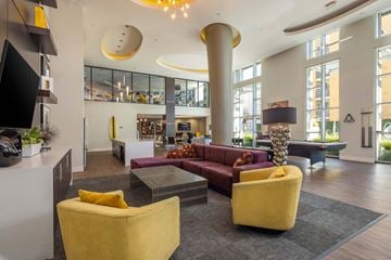 Glendale apartment for rent - A modern living room with a yellow chair and a red couch.