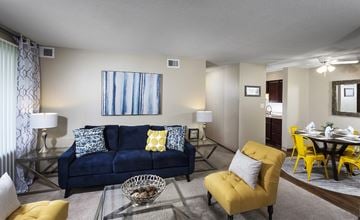 West Des Moines townhouse for rent - A living room with a blue couch and yellow chairs.