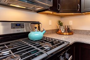 Johnston apartment for rent - a teapot on the stove in a kitchen with a microwave