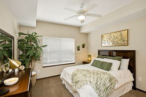 West Des Moines apartment for rent - A bedroom with a bed, a ceiling fan, and a painting on the wall.