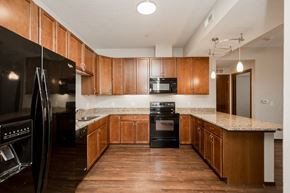 West Des Moines apartment for rent - A kitchen with wooden cabinets and black appliances.