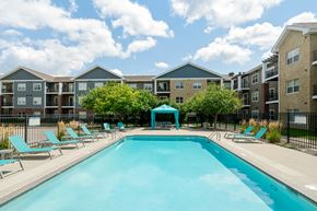 West Des Moines apartment for rent - A swimming pool surrounded by sun loungers and apartment buildings.