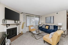 West Des Moines townhouse for rent - A living room with a fireplace, a blue couch, and a television.